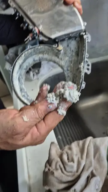 Componente interno durante reparo de máquina de lavar